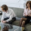 Woman in White Dress Shirt Sitting Beside Woman in White Long Sleeve Shirt
